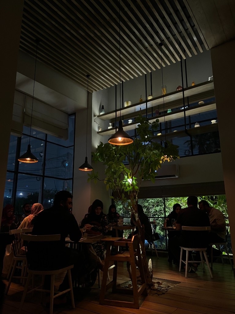 A warmly lit café interior at night in Karachi, Pakistan