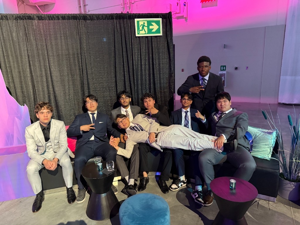 A group of friends dressed in suits relaxing together at an event