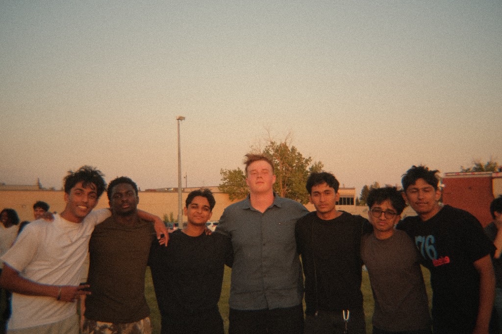 A group of friends posing together in a warm film-style photograph