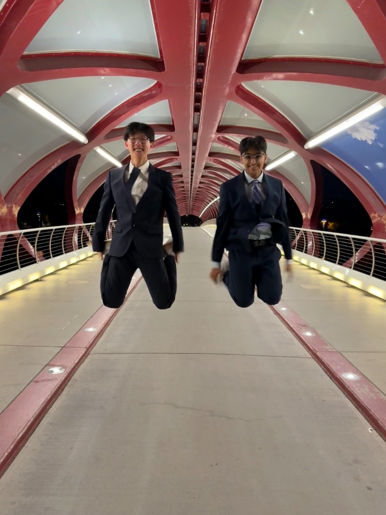 Ali and a friend jumping inside Calgary's illuminated Peace Bridge