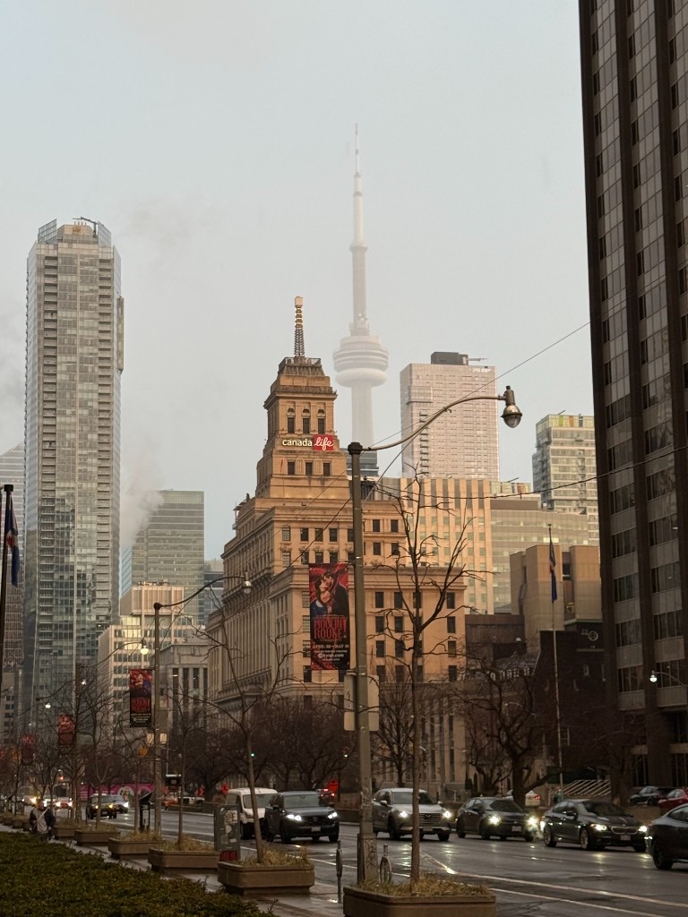 Toronto city buildings and the CN Tower rising through mist